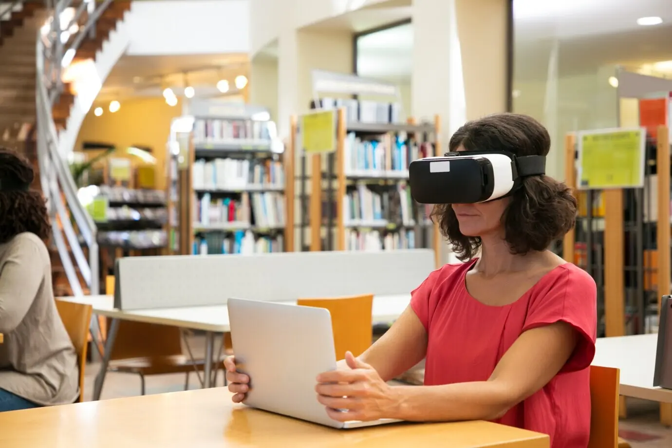 Eine Frau benutzt in einer Bibliothek einen VR-Simulator.