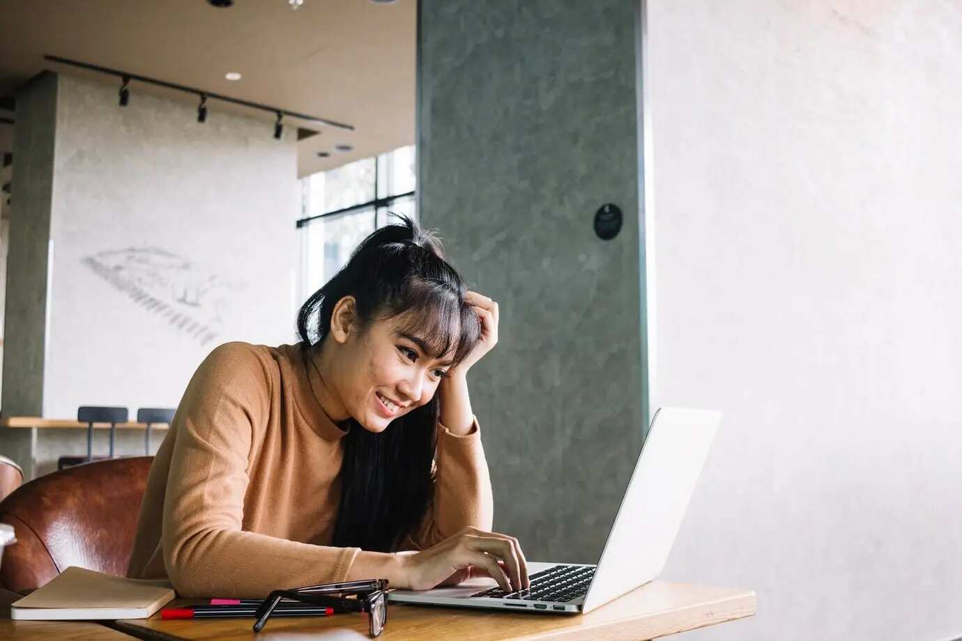 Asiatische Frau, die einen Laptop benutzt